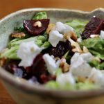 A beet salad with goat cheese in a hand-crafted glazed salad bowl.