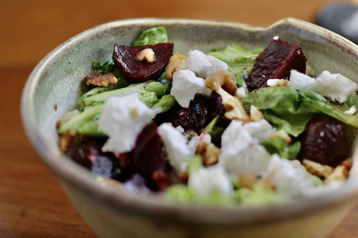 A beet salad with goat cheese in a hand-crafted glazed salad bowl.