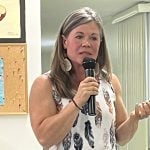Kim Davis speaks into a microphone at a meeting of the Oldman Lease Holders Association in Vauxhall, Alberta.
