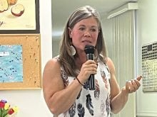 Kim Davis speaks into a microphone at a meeting of the Oldman Lease Holders Association in Vauxhall, Alberta.