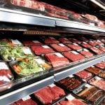 Various cuts of beef on display in the meat section of a grocery store.