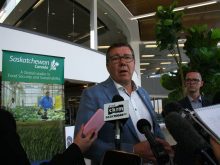 Saskatchewan Premier Scott Moe takes questions from reporters in Saskatoon International Airport.