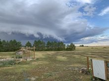 A clear view of a storm front as the cloud moves in over a prairie yard site.