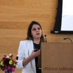 Sheila Andrade, a University of Saskatchewan PhD student, stands at a podium presenting her research.