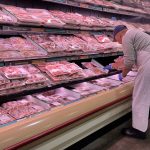 A butcher stocks meat at a grocery store in Mississauga, Ontario.