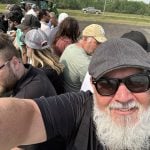 Don Norman takes a selfie of himself and mire than a dozen others piled onto what he calls "the hay bale express" during a farm tour.
