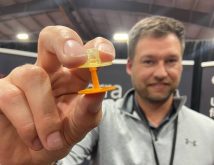A man holds a biodegradable ear tag for pigs close to the lens of the camera.