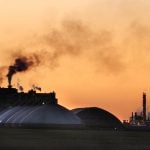 The potash mine at Belle Plaine, Saskatchewan, is silhouetted agains the orange sky at sunset.