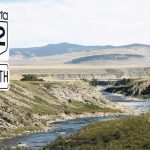 A road sign for Alberta's "Highway 22 North" stands overlooking a river in the background near the province's Waldron Ranch.