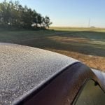 Frost has formed on top of the roof of a red truck.