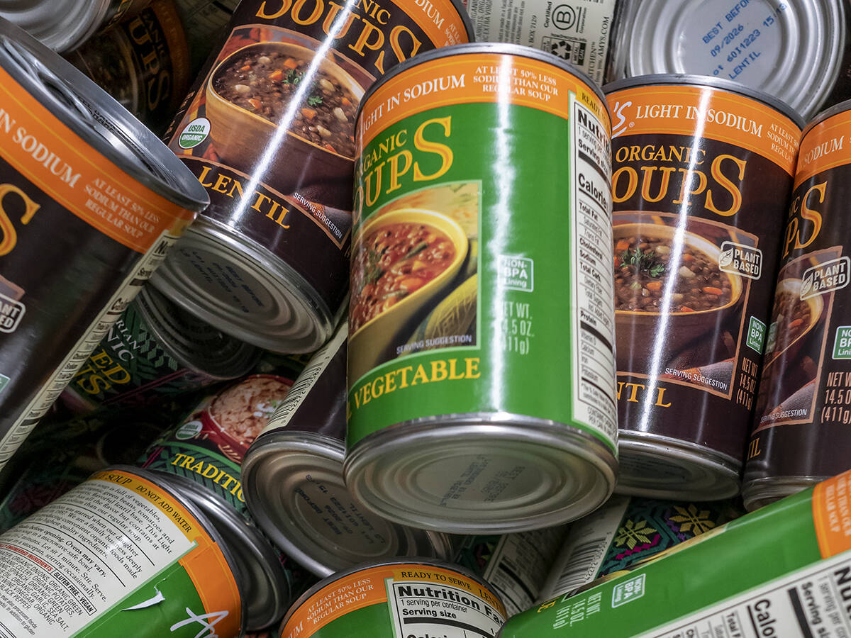 A variety of Annie's Organic Soups cans sit on top of one another in some kind of container.