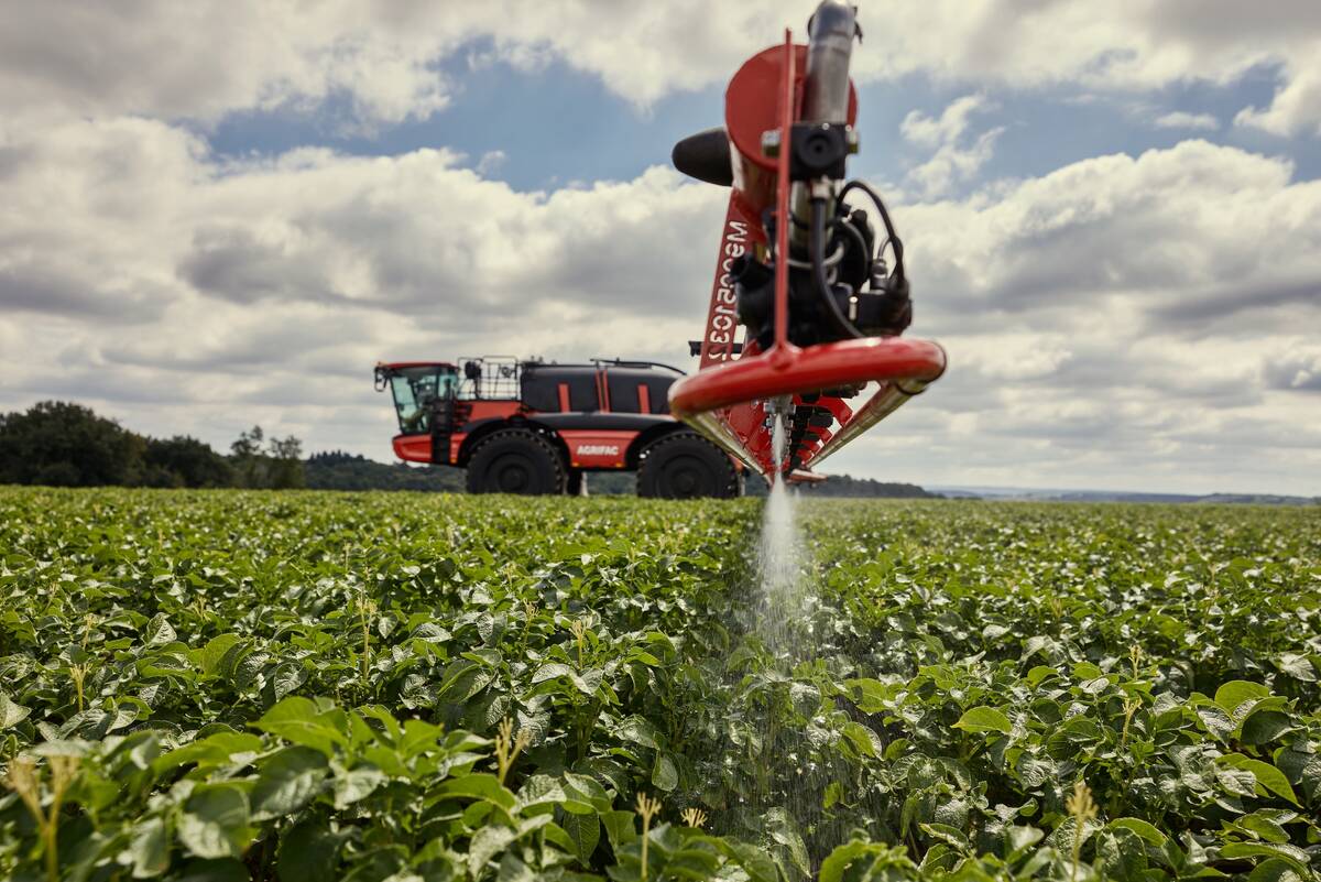 Close-up of the spray leaving the nozzles mounted on the boom of a new Agrifac sprayer landing on the green crop immediately below.