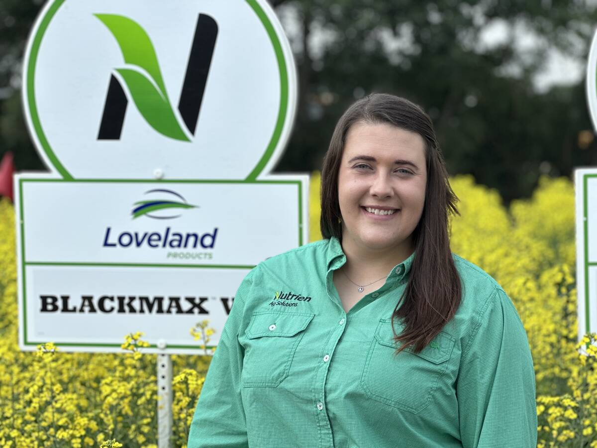 Shelby LaRose, crop nutrition product manager with Nutrien Ag Solutions, stands in front of a blooming canola test plot at the Ag in Motion farm show near Langham, Saskatchewan.