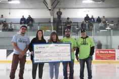 Five people stand at centre ice in a hockey arena holding a large cheque for $35,000 from "HyLife Fun Days" made payable to the "Yellowhead Recreation Centre."