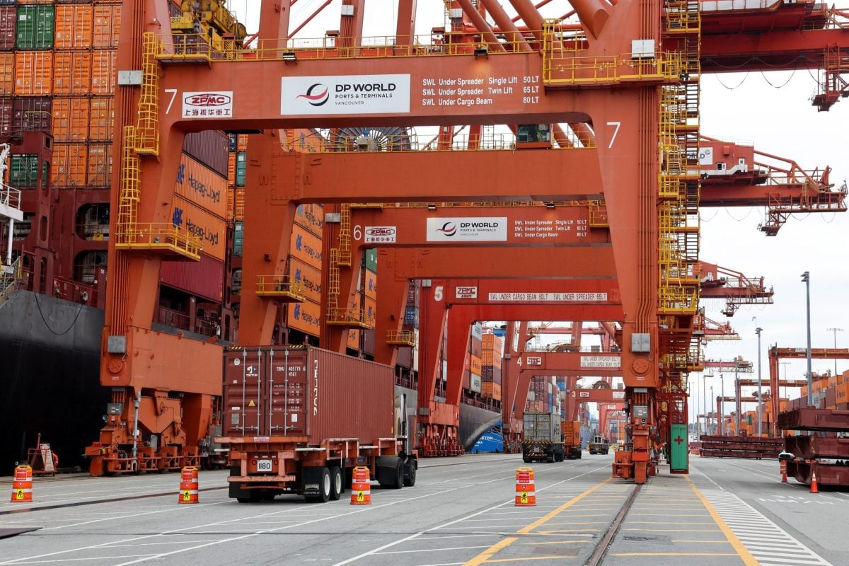 A truck carries a container near a cargo ship bound for Japan at the Centerm container ship terminal at the Port of Vancouver in Vancouver, British Columbia, Canada August 3, 2025. REUTERS/Chris Helgren