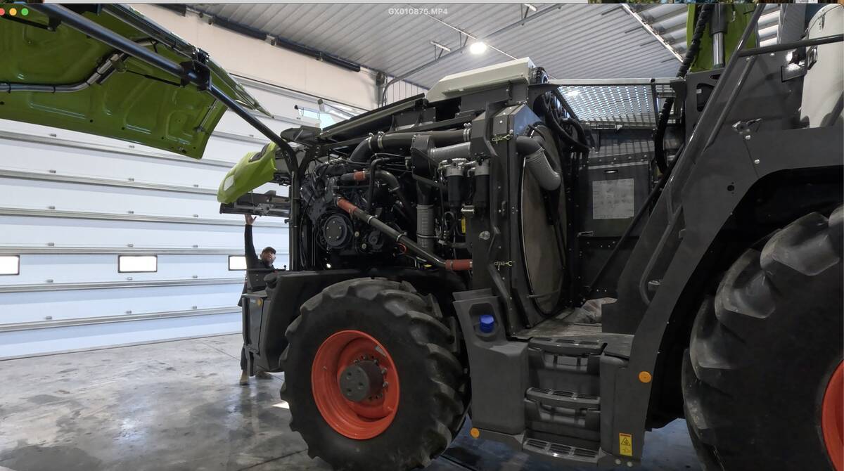 The engine covering is removed to reveal the diesel power plant and its cooling system on a new Claas forage harvester.