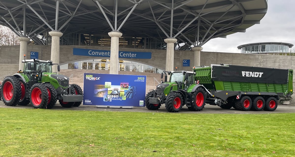Two Fendt tractors are parked beside an