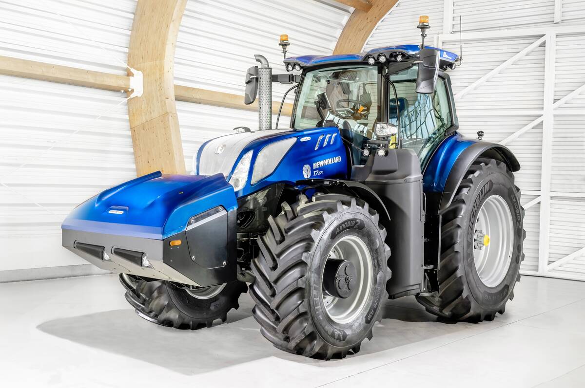 A large blue tractor with an unusually wedge-shaped front end sits on display in a machine shed.