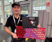 Padraic George shows the fence system he developed to keep rodents out of combines.