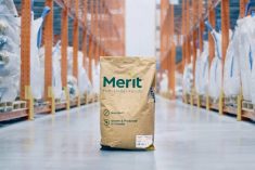 A brown bag sits on the floor in a warehouse with the "Merit Fuctional Foods" name on it and "Non-GMO," as well as "Made in Canada."