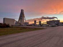 A Saskatchewan potash mine is silhouetted against the rising sun.