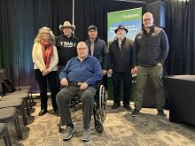 A group of people stand on a stage at the Western Canadian Crop Production Show, 2026 inductees into the Saskatchewan Agricultural Hall of Fame.