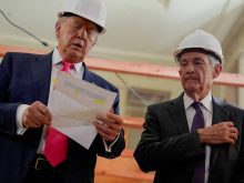 U.S. President Donald Trump is wearing a white hard hat and holding a document standing next to Federal Reserve Chair Jerome Powell during a tour of the Federal Reserve Board building, which is currently undergoing renovations, in Washington, D.C., U.S., July 24, 2025.
