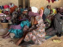 A displaced woman from Dalanj braids her grandmother's hair at a displacement registration center in El Obeid, North Kordofan State, Sudan, January 15, 2026.