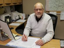 Gord Schroeder, executive director of the Saskatchewan Sheep Development Corporation, is seated at his desk.
