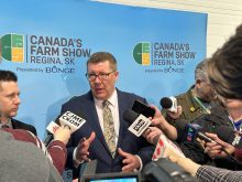 Premier Scott Moe speaks to reporters after opening Canada's Farm Show in Regina.