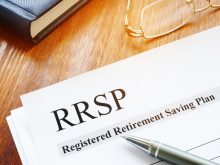 A close-up of the top left corner of a document sitting on a desk with a pen on top of it that reads, "RRSP - Registered Retirement Savings Plan."