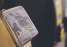 A close-up of the word, "Diesel" written on the handle of a pump at a gas station.