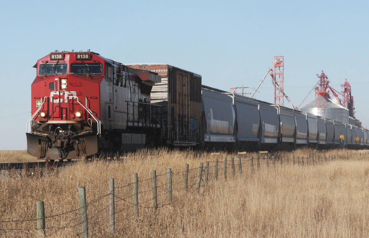 A CP grain train moves past an inland terminal on a sunny day.