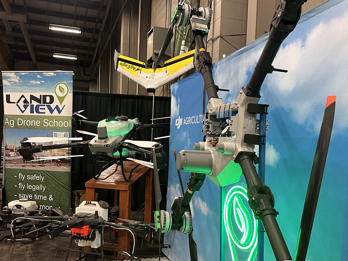 A number of drones are on display in a booth at at trade show.