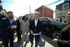 Canada's Prime Minister Mark Carney is smiling as he walks on a street with a Liberal candidate in Quebec.